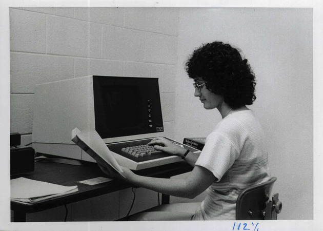 Library cataloger, Beth Donovan, typing bibliographic data on a new computer terminal